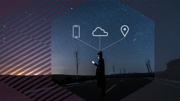 Person with phone standing in the road in a hexagon with icons of phone, cloud, and a pinpoint above their head